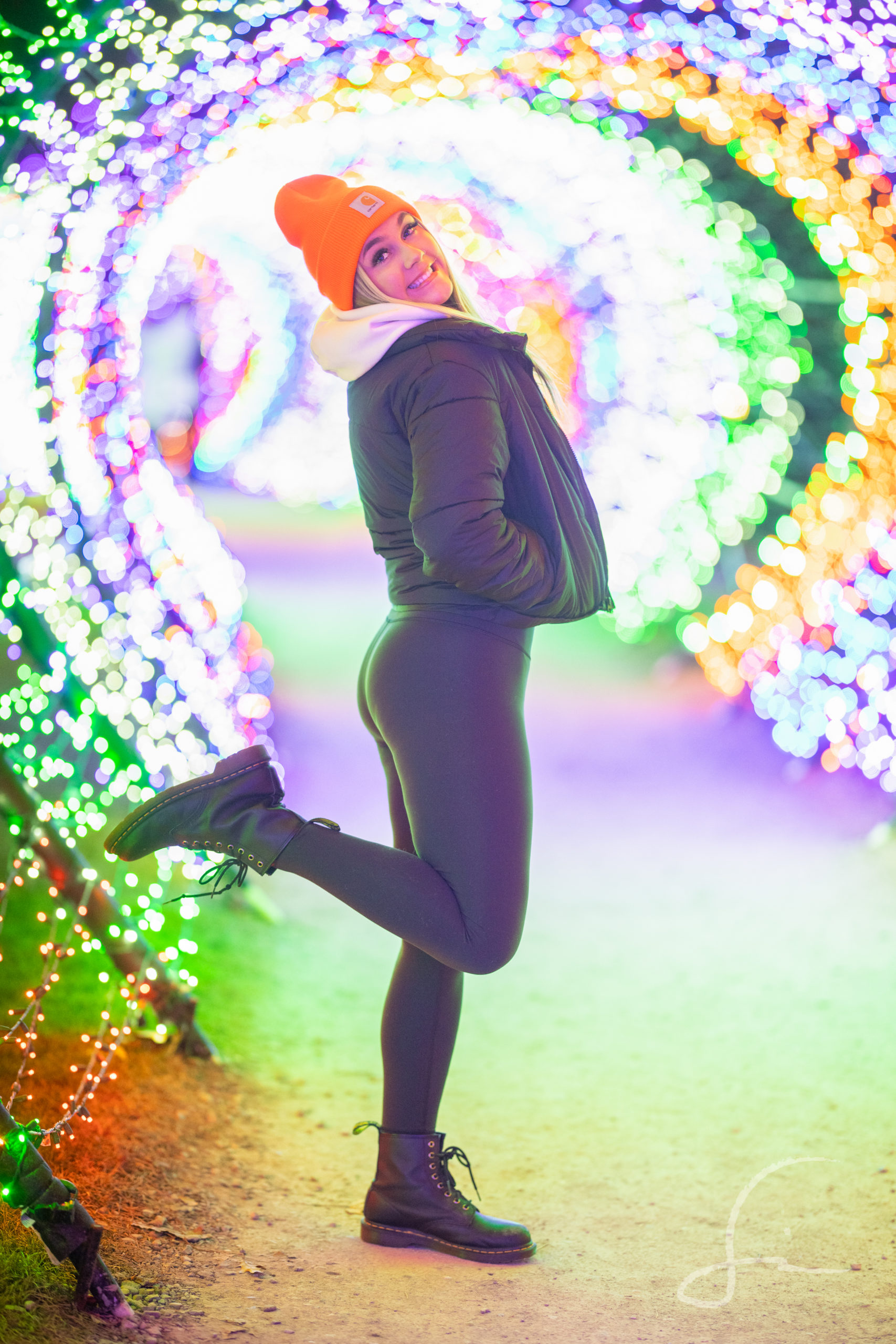 High School Senior Girl in a tube of Christmas Lights wearing leggings, a jacket, and a beanie hat