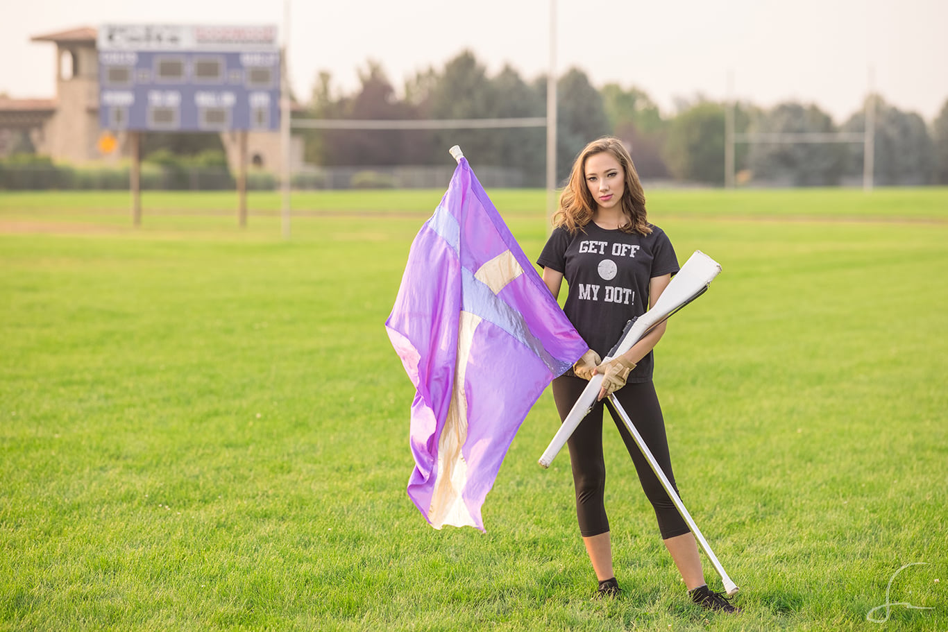 high school senior girl with color guard flag and rifle on capital high school field in idaho